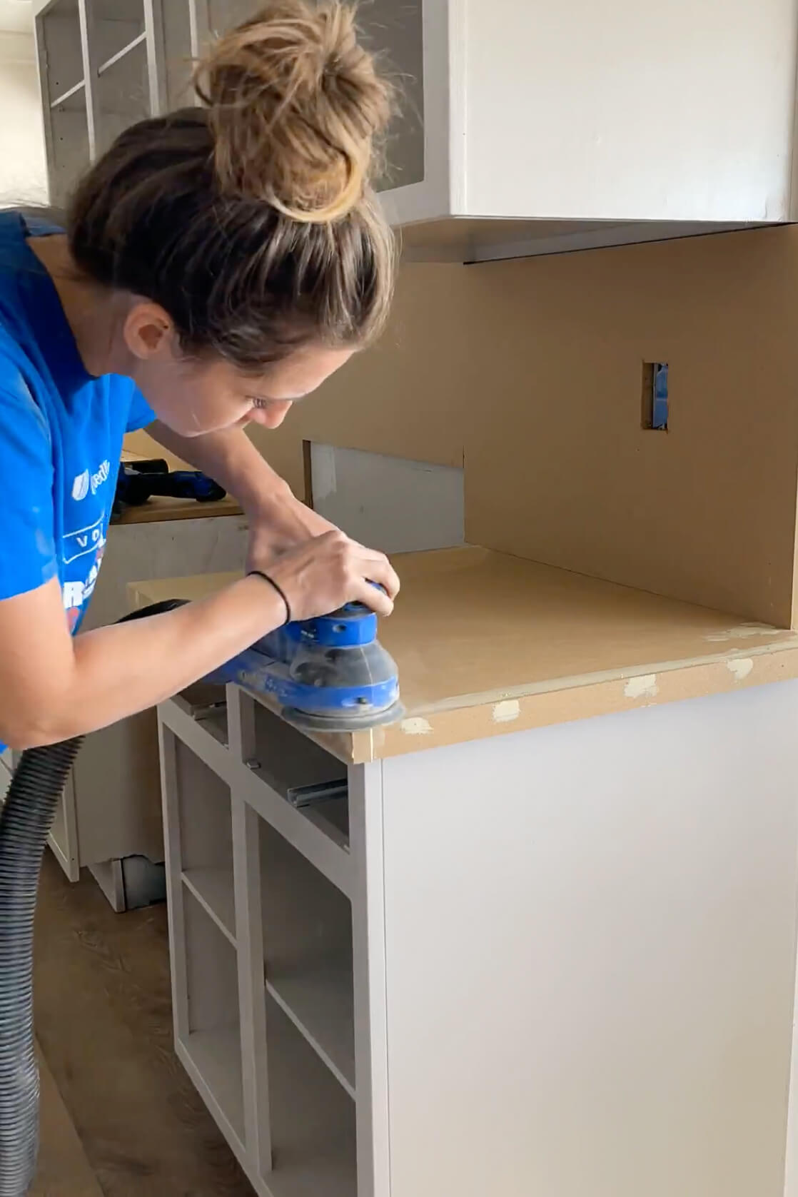 Sanding to prep for a DIY epoxy countertop.